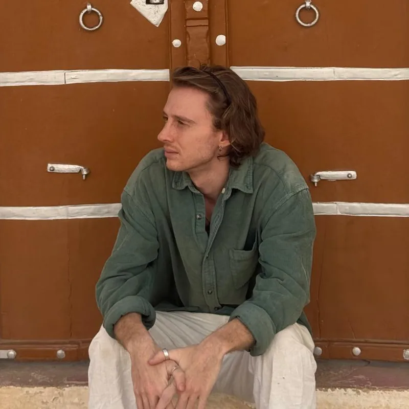 Daniel Delaway sitting in front of a carved wooden door